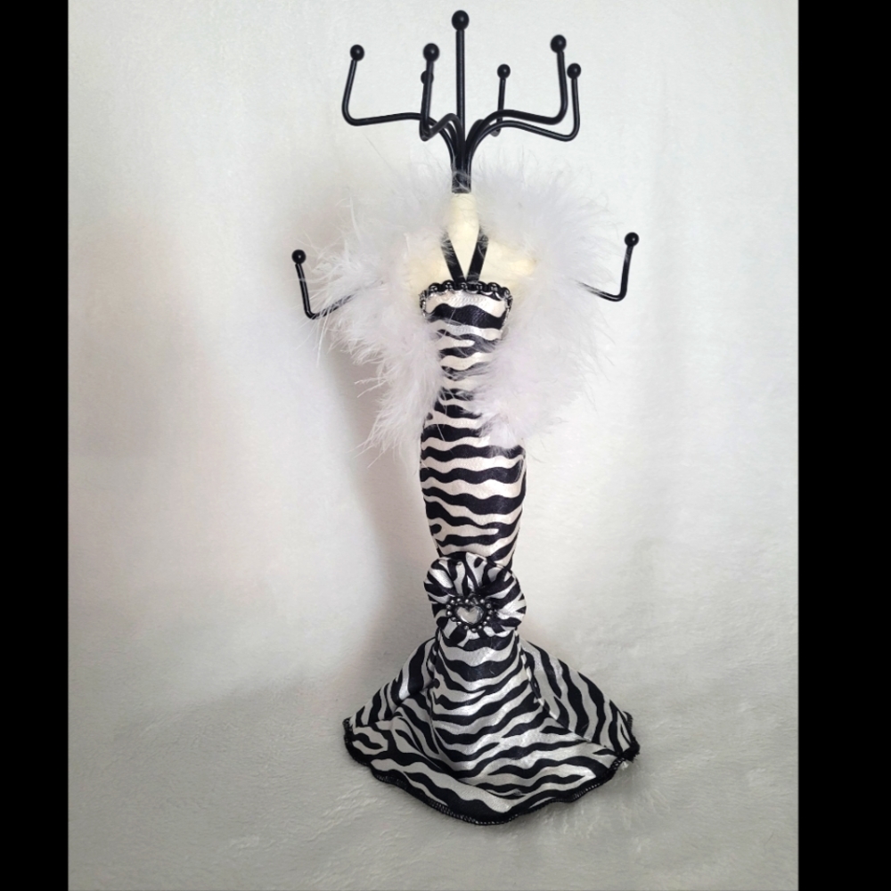 Jewelry stand/holder. 9 prongs. Zebra dress manican with white fluffy boa.